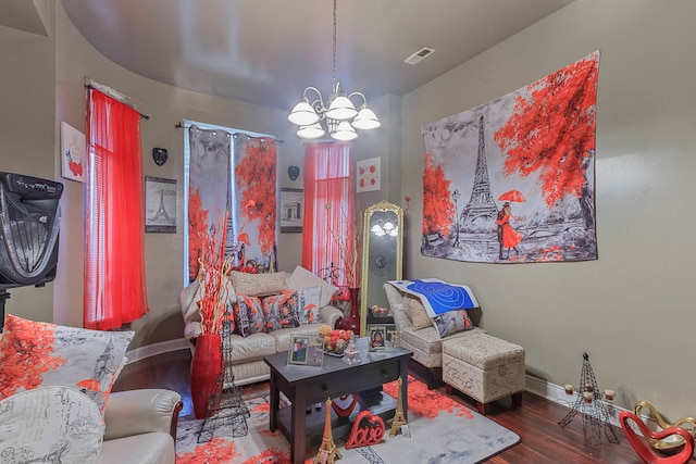 living room featuring a notable chandelier and dark wood-type flooring