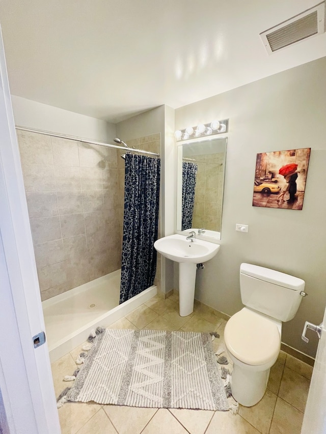 bathroom featuring curtained shower, toilet, and tile floors