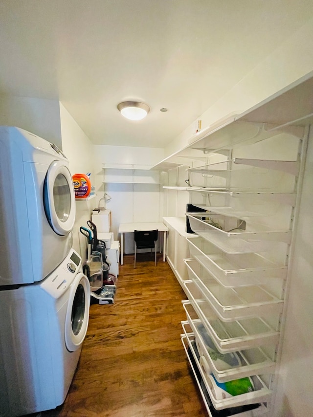 clothes washing area featuring stacked washer and dryer and dark hardwood / wood-style floors