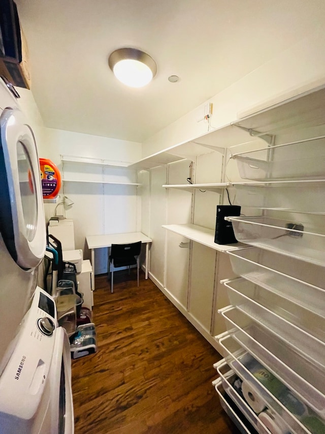 walk in closet featuring dark hardwood / wood-style flooring and stacked washer and dryer