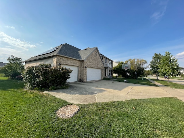 view of home's exterior featuring a lawn, a garage, and solar panels