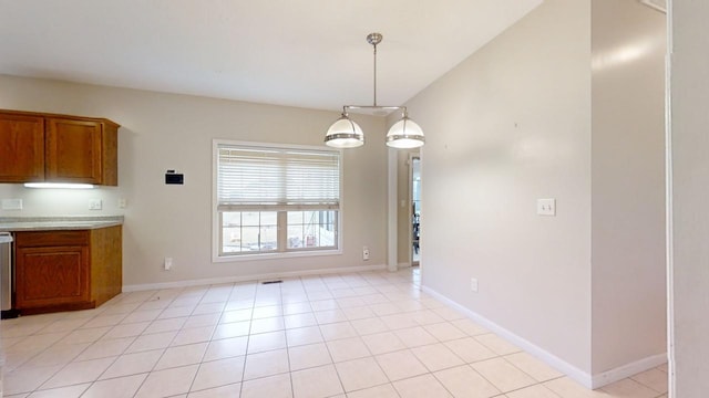 unfurnished dining area with light tile flooring and a notable chandelier