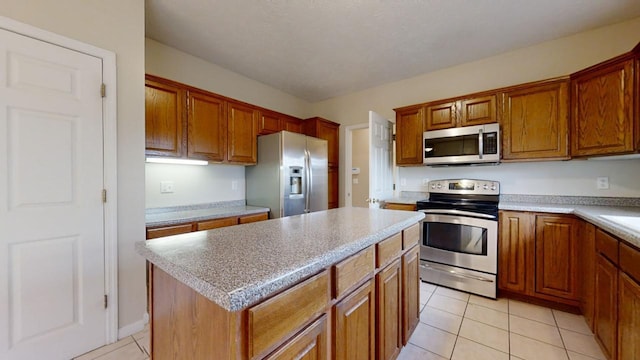 kitchen featuring a kitchen island, stainless steel appliances, and light tile floors