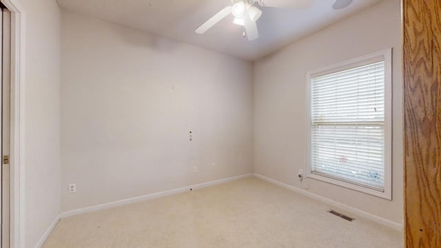 empty room featuring ceiling fan and light colored carpet