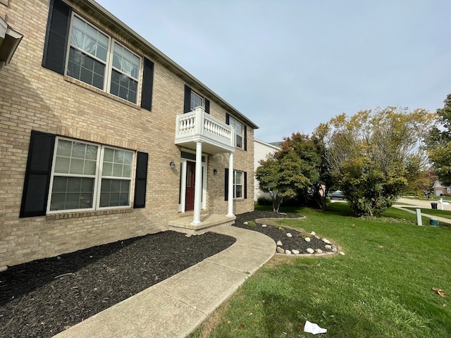 back of property with a balcony and a lawn