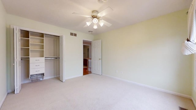 unfurnished bedroom featuring ceiling fan, a closet, and light colored carpet