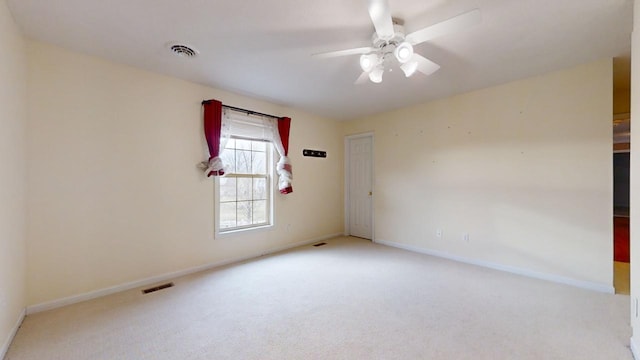 empty room with ceiling fan and light carpet