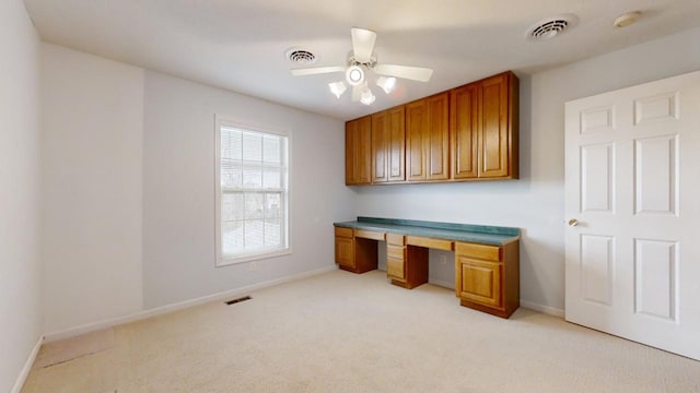 unfurnished office with ceiling fan and light colored carpet