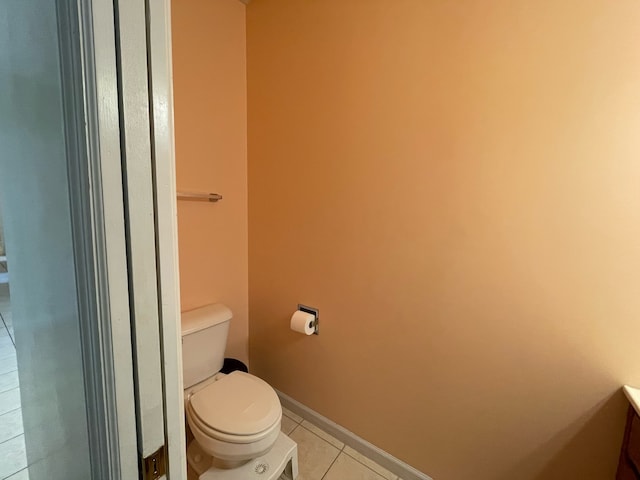 bathroom with toilet, vanity, and tile flooring