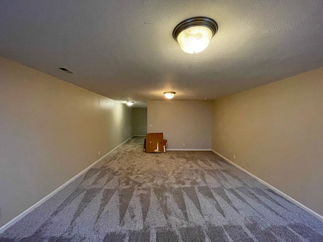 basement featuring carpet flooring and a textured ceiling