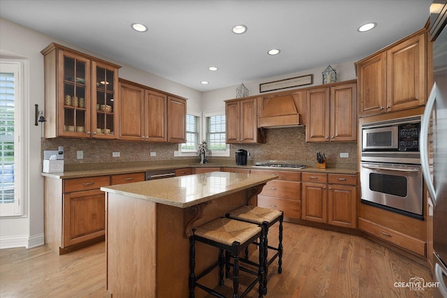 5085 Half Round Rd, Oswego, IL 60543 - kitchen featuring appliances with stainless steel finishes, custom range hood, brown cabinets, and recessed lighting