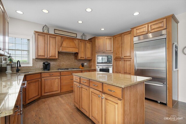 5085 Half Round Rd, Oswego, IL 60543 - kitchen featuring built in appliances, a sink, light wood-type flooring, light stone countertops, and recessed lighting