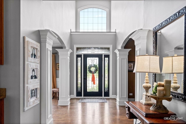 5085 Half Round Rd, Oswego, IL 60543 - foyer featuring decorative columns, arched walkways, a towering ceiling, wood finished floors, and baseboards
