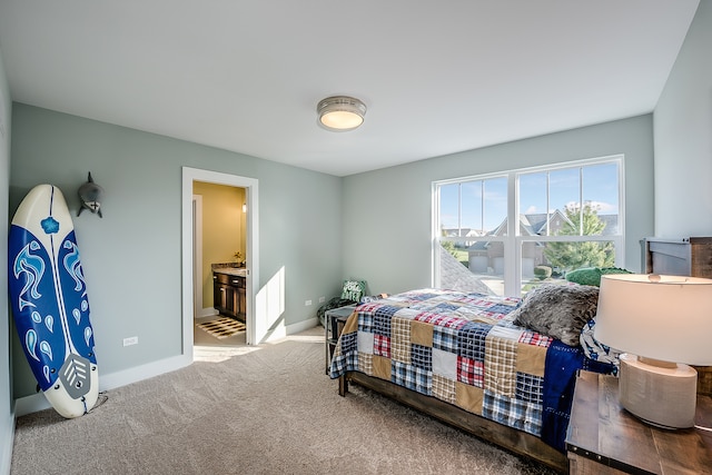 bedroom featuring light carpet and ensuite bath