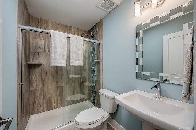 bathroom featuring walk in shower, sink, and toilet