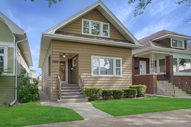 bungalow-style house with a front yard and covered porch