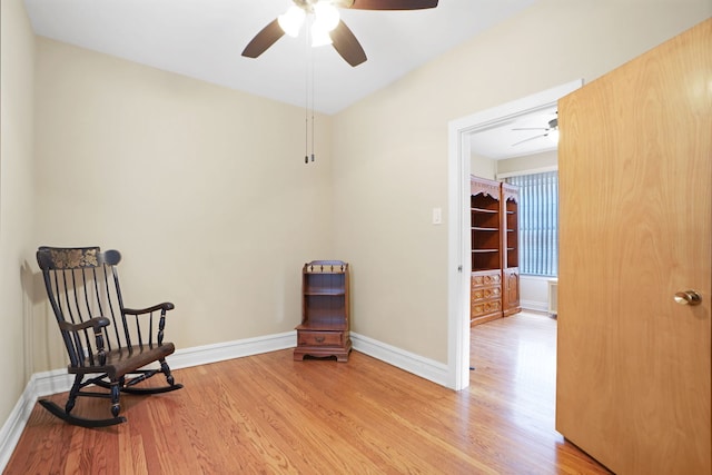 living area featuring light hardwood / wood-style floors and ceiling fan