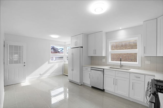 kitchen featuring light tile flooring, sink, white cabinets, dishwasher, and stove