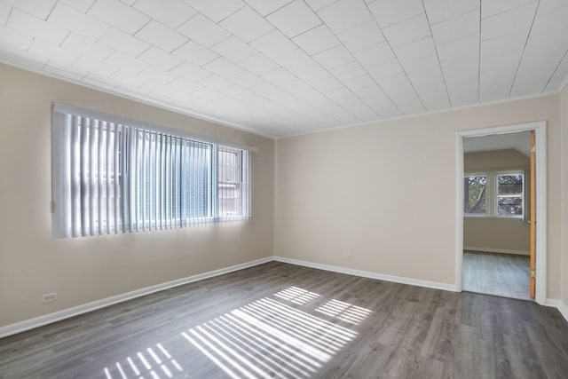 empty room with crown molding and dark hardwood / wood-style floors