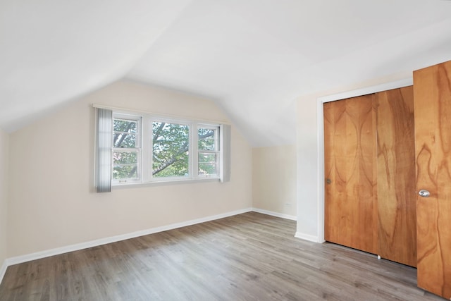 bonus room featuring lofted ceiling and light hardwood / wood-style flooring