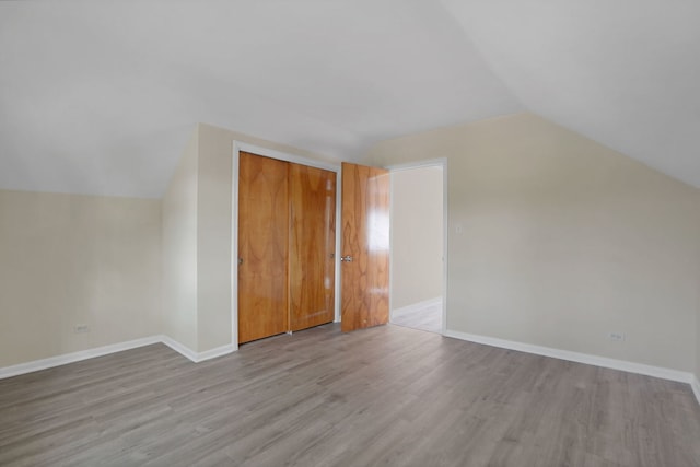 additional living space with lofted ceiling and light hardwood / wood-style floors