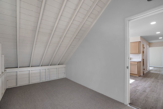 bonus room featuring light hardwood / wood-style flooring and lofted ceiling with beams