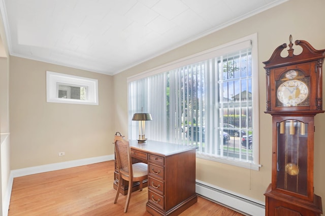 office space with baseboard heating, light hardwood / wood-style floors, a wealth of natural light, and ornamental molding