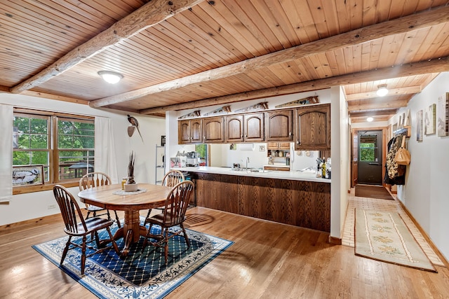 dining area featuring sink, wooden ceiling, light wood-type flooring, and beam ceiling