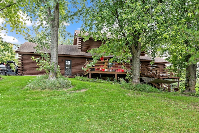 back of property featuring a deck and a yard