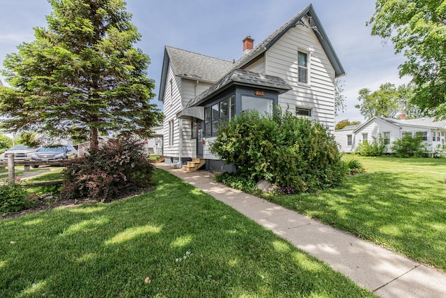 616 N Pleasant St, Princeton, IL 61356 - view of side of property featuring entry steps, a chimney, a shingled roof, and a lawn