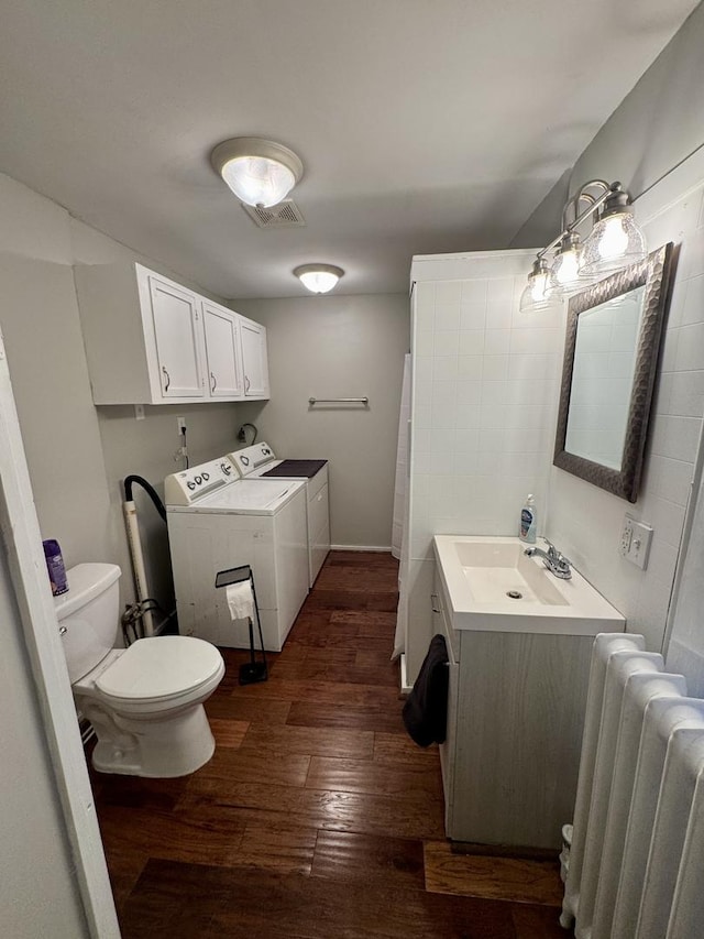 616 N Pleasant St, Princeton, IL 61356 - full bath with radiator heating unit, washer and clothes dryer, hardwood / wood-style flooring, toilet, and vanity
