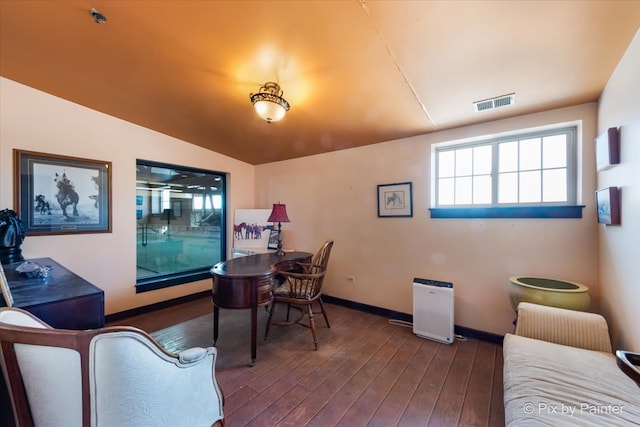 dining space featuring lofted ceiling and dark hardwood / wood-style floors