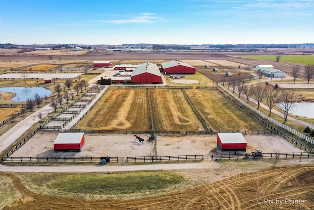 birds eye view of property featuring a water view and a rural view