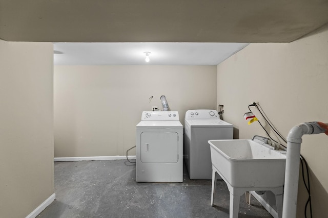 clothes washing area featuring laundry area, independent washer and dryer, and baseboards