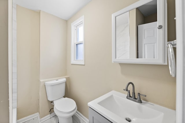 bathroom with vanity, toilet, and baseboards