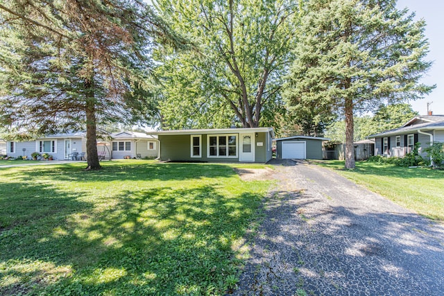 single story home with a front yard, an outdoor structure, and a garage