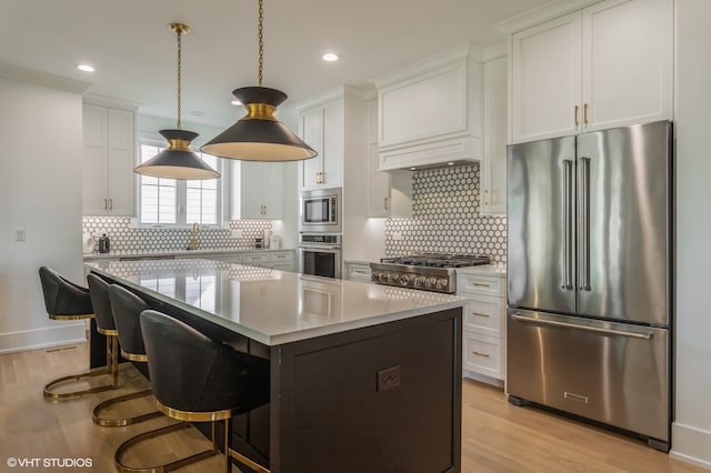 kitchen featuring a kitchen island, light hardwood / wood-style floors, decorative backsplash, and stainless steel appliances