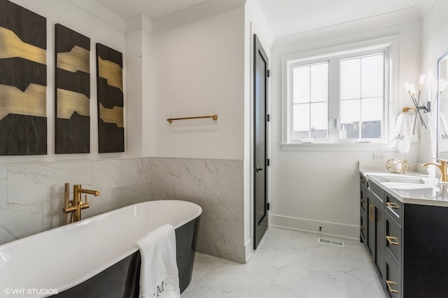 bathroom featuring ornamental molding, vanity, tile patterned floors, tile walls, and a bathtub