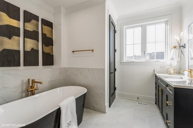 full bath featuring marble finish floor, vanity, visible vents, and a soaking tub