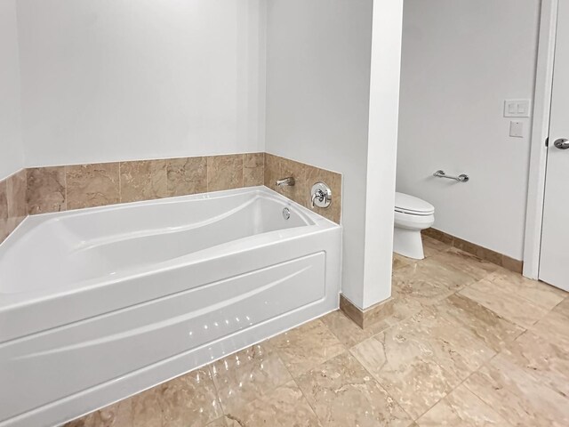 bathroom with toilet, tile patterned floors, and a tub to relax in