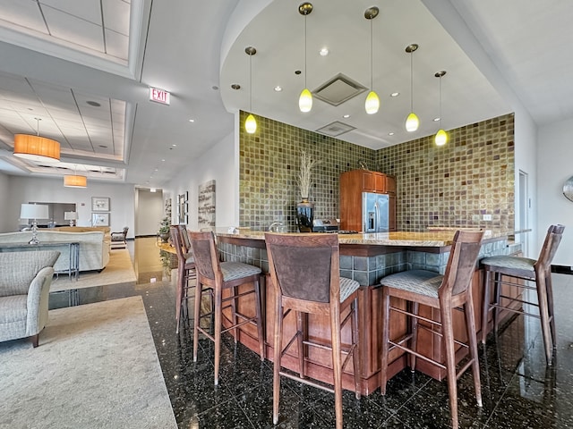 interior space with dark tile patterned flooring, stainless steel fridge with ice dispenser, and decorative light fixtures