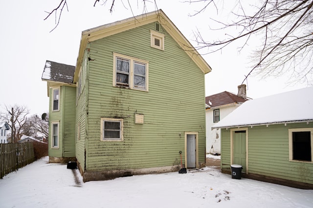 view of snow covered rear of property