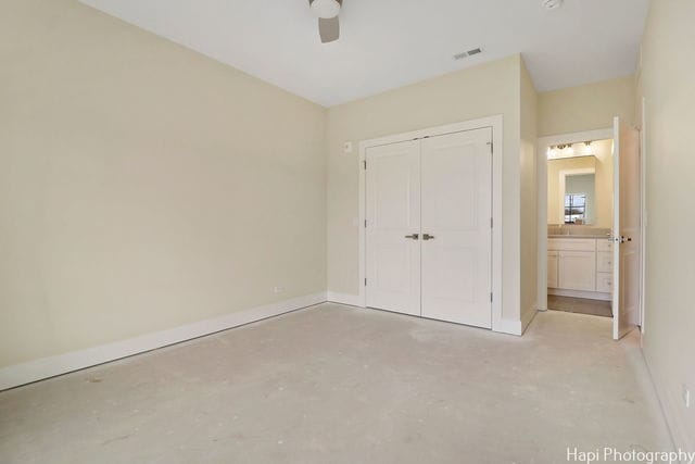 unfurnished bedroom with ceiling fan and a closet