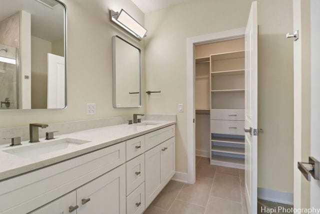 bathroom featuring vanity, tile patterned floors, and a shower with door