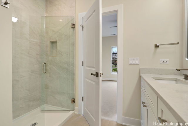 bathroom featuring vanity and a shower with door