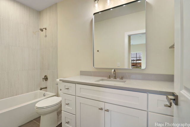 full bathroom with toilet, vanity, and tiled shower / bath