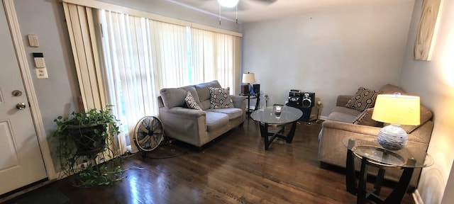 living room featuring plenty of natural light, ceiling fan, and dark wood-type flooring