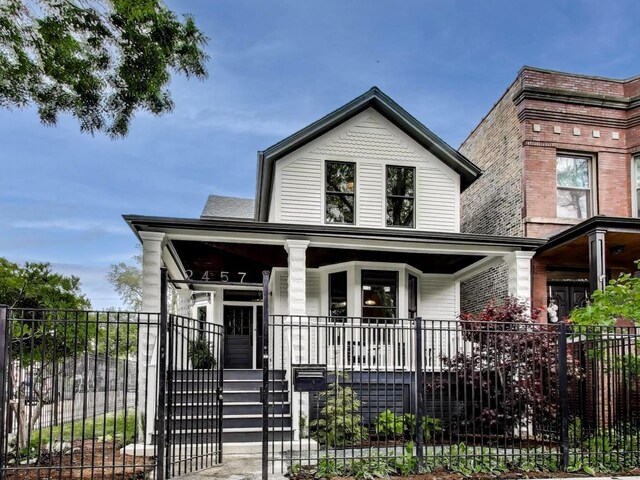 2457 N Talman Ave, Chicago, IL 60647 - view of front facade with a porch and a fenced front yard