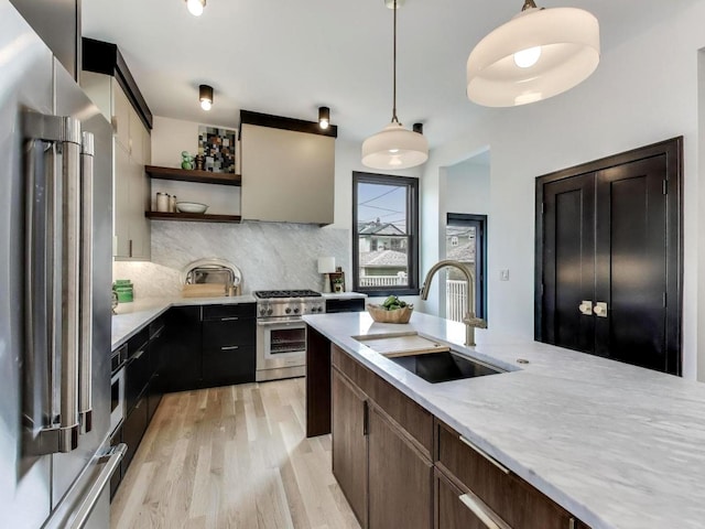 2457 N Talman Ave, Chicago, IL 60647 - kitchen with appliances with stainless steel finishes, a sink, open shelves, backsplash, and light wood-style floors