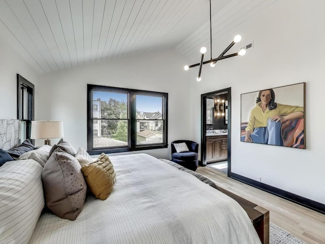 2457 N Talman Ave, Chicago, IL 60647 - bedroom with a chandelier, wood finished floors, lofted ceiling, ensuite bathroom, and baseboards